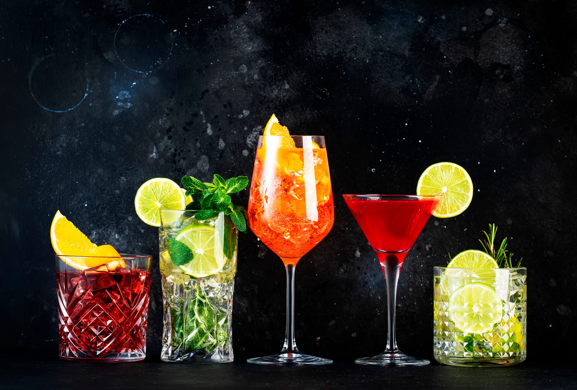 Most popular trendy cocktails set: Spritz, negroni, mojito, gin tonic and cosmopolitan on gray bar counter background